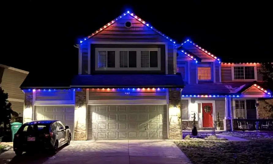 Two-story house with a red, white and blue roofline above a two-car garage.